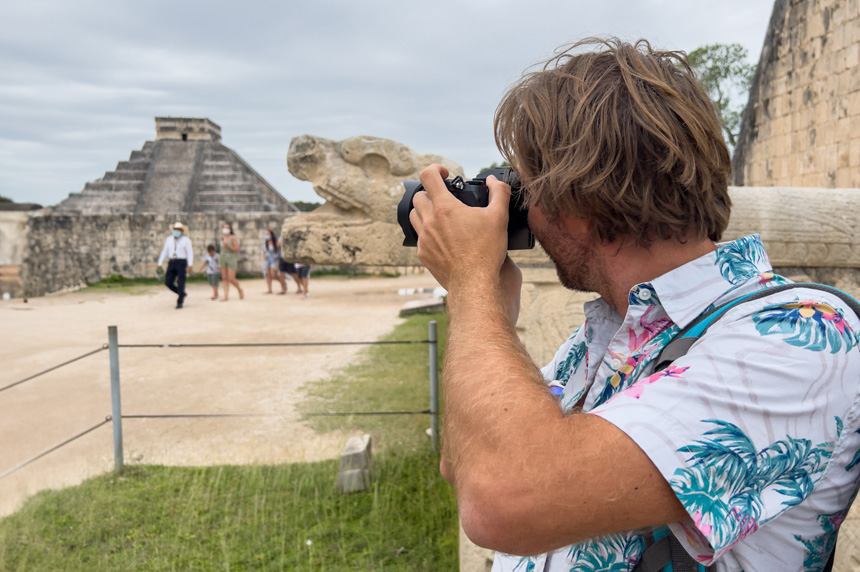 Male tourist in Hawaiian shirt taking picture of pyramids