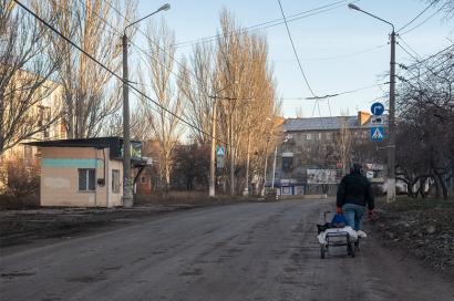 Image: Man carrying a cart with supplies through the street